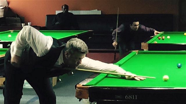 Round of 16 action at the 2015 United States National Snooker Championship, with Ian O'Mahony down at the table, while in the background, Vaishal Talati contemplates his next shot - Photo  SnookerUSA.com